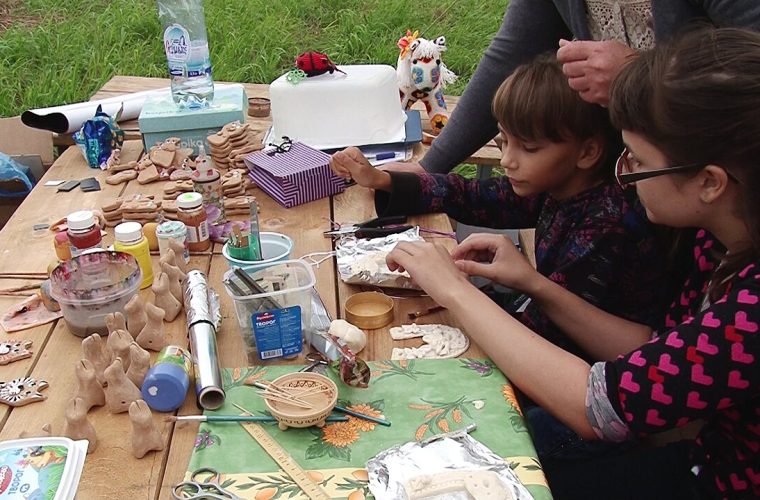Groep kinderen op podium in Cultuurhuis Stunt, Delft, met pannenkoeken op tafel
